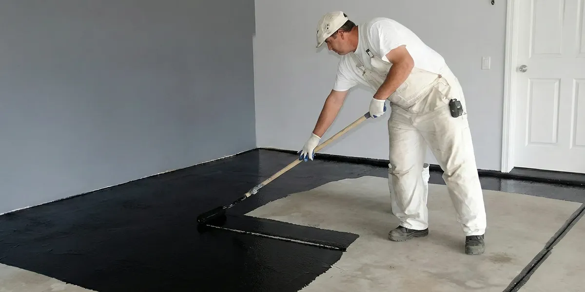 basement waterproofing professional applying waterproof coating to protect a basement floor in Long Beach, CA