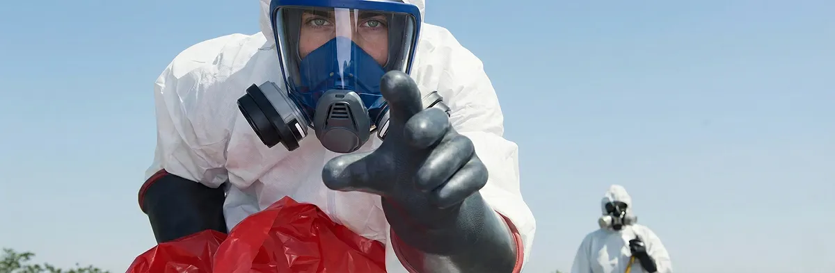 sewage clean up technician wearing protective gear handling biohazard materials in Long Beach, CA